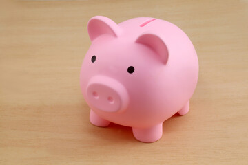 Pink piggy bank on wooden background 