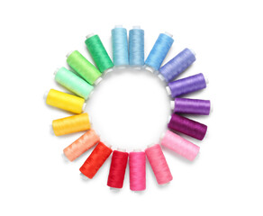 Frame made of colorful thread spools on white background