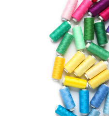 Colorful thread spools on white background
