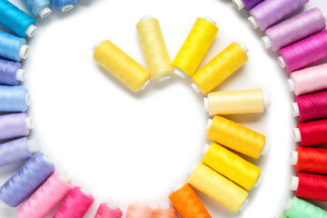 Colorful thread spools on white background
