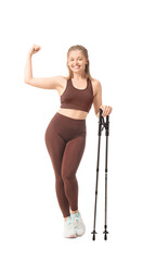 Sporty young woman with walking poles showing muscles on white background