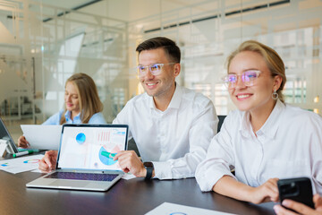 Group of professionals collaborating in a modern office with digital presentations and documents