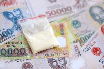 Vietnamese dong currency money bills and cocaine pack close up. The concept of drug trafficking