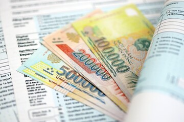 Vietnamese dong money bills on tax form close up. Taxation and accounting concept