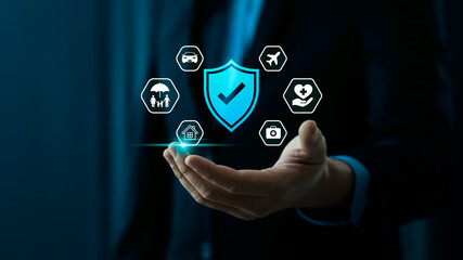 Comprehensive insurance protection and financial security concept with businessman hand holding shield check mark, of home, car, family, travel, health, medical care coverage for safety and stability