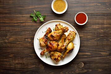Grilled roasted chicken drumsticks served with sauce