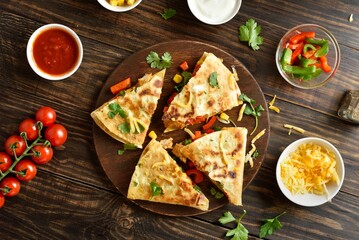Quesadillas with fresh vegetables on wooden table
