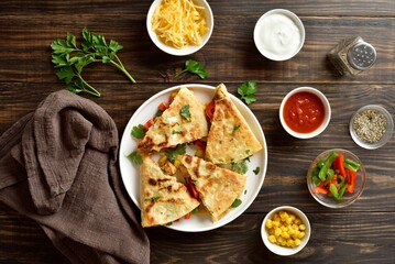Chicken quesadilla with fresh vegetables on wooden table