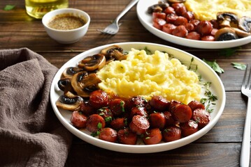 Mashed potatoes with roasted sweet and spicy sausage bites and mushrooms