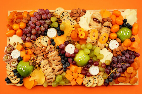 Healthy Halloween fun food mix: cheese ghosts and mummies, banana ghosts and grapes, blueberries and blackberries. Party spooky snacks for kids