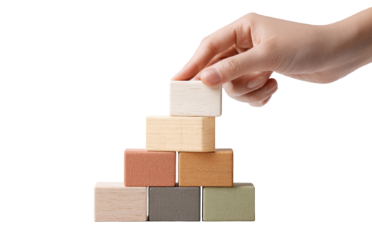 Hand placing a light beige wooden block atop a pyramid of colorful wooden blocks - Powered by Adobe