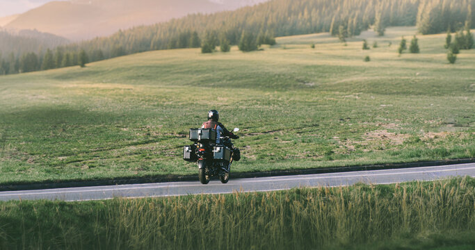 Motorcyclist driving through outdoor mountain view