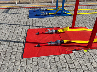 Two pairs of type 3 fire hoses on the ground, for use in a firefighting competition between firefighters.
