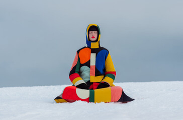 Fashion figure in colorful geometric coat meditating in snow, symbol of mindfulness, peace and creative expression. Perfect for lifestyle campaigns, branding, and digital visuals.