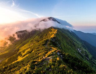 Mountain ridge at sunrise, shrouded in clouds