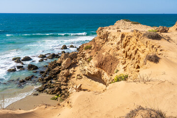Whimsical white and sandy cliffs on the coast against the backdrop of the turquoise-blue sea and the blue sky
