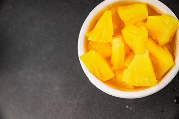 Pineapple canned chunks sweet fruit dessert tasty snack fresh delicious gourmet food background on the table rustic top view copy space keto and paleo diet vegetarian and vegan food