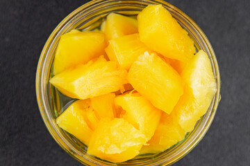 Pineapple canned chunks sweet fruit dessert tasty snack fresh delicious gourmet food background on the table rustic top view copy space keto and paleo diet vegetarian and vegan food