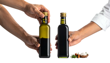 Two hands holding olive oil and balsamic vinegar bottles, salt, greens, and turmeric