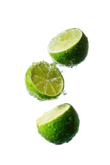 Three lime halves in mid-air, glistening with water droplets