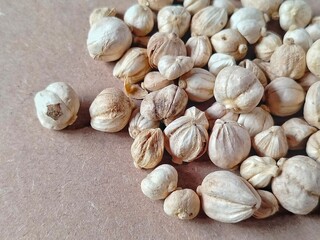 piles of white cardamom scattered over a light brown surface 