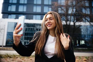 Young Professional Woman Smiling While Video Calling in an Urban Setting During Daylight Hours