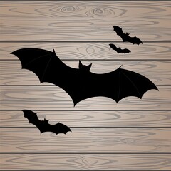 Silhouette bats flying against a light brown wood grain backdrop