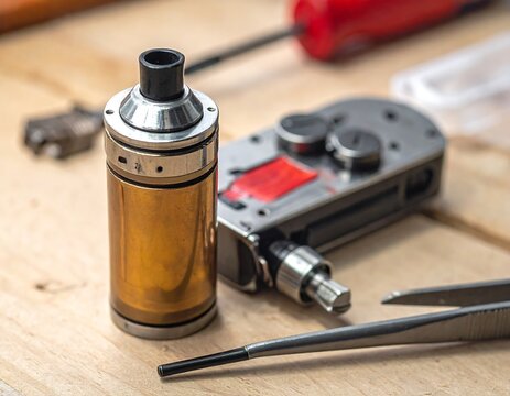 Close-up of disassembled electronic components, including a cylindrical battery holder, alongside a device's parts on a wooden surface