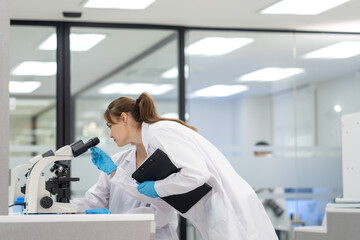 Scientist examines sample through microscope in a modern laboratory setting