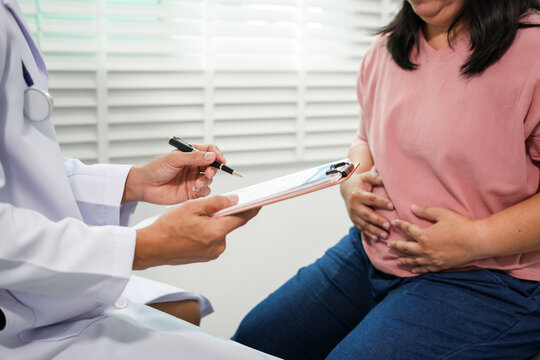 The doctor will take a medical history and assess the Asian woman's abdominal pain and discuss diagnosis and management of gastrointestinal problems, excess fat, obesity, or other health problems.