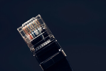 Close-up of a network cable connector highlighting its gold contacts, symbolizing internet connectivity and data transfer