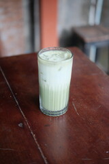 Refreshing iced matcha latte on a rustic wooden table, perfect for a trendy cafe menu or a healthy lifestyle blog post. Summer drink inspiration