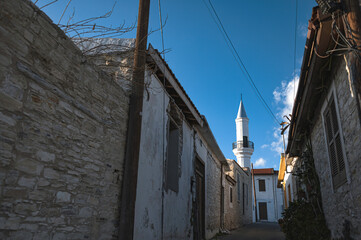 Minaret tower of Hamidiye Mosque rising above traditional stone houses in pano lefkara, cyprus