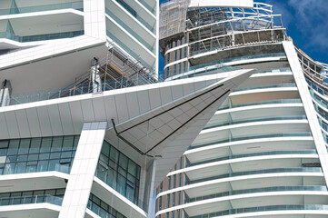 Modern white skyscraper under construction with glass balconies. Limassol, Cyprus