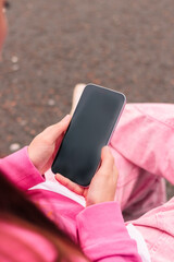 Woman in pink holding phone, over the shoulder view