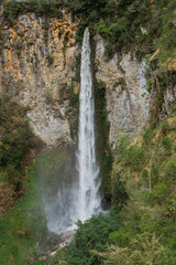 Obraz premium Majestic waterfall cascading down rocky cliff lush greenery nature photography serene landscape views