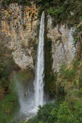 Majestic waterfall cascading down rocky cliffs nature photography lush green environment aerial view