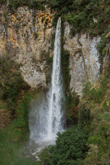 Majestic waterfall cascading down rocky cliffs nature scene scenic landscape lush green environment aerial view serenity
