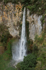 Majestic waterfall cascading down rocky cliffs nature landscape photography lush green environment aerial view