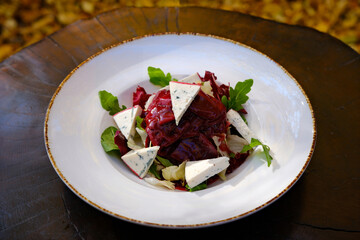 salad with cherry sauce and blue cheese with mix of berries, nuts, feta cheese, bacon and raspberry sauce on vintage background. Space for text. High quality photo
