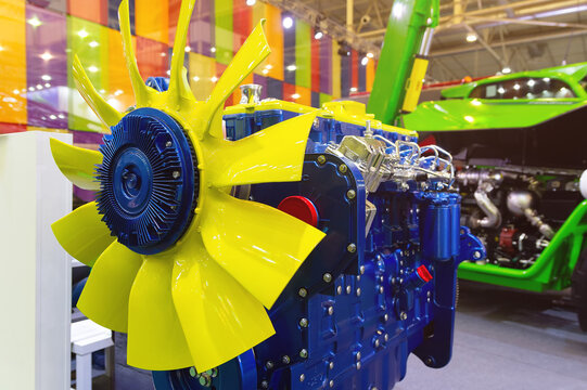 Brightly colored internal combustion engine displayed on a stand