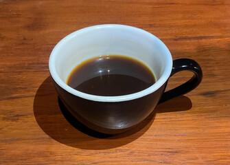 Steaming hot black coffee in a white mug, perfect for cozy autumn mornings. Drink beverage.  