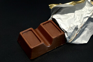 Chocolate with filling in packaging on a black background.