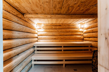 cozy wooden sauna bench corner lit, log walls and tiled floor, soft lamp glow over two tier benches, empty serene atmosphere suggesting post cleaning and ready wellness retreat