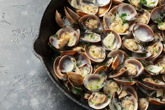 Steamed Clams with garlic, parsley and white wine in a cast iron pan