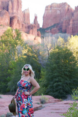 Blonde woman wearing alien sunglasses poses at Crescent Moon Ranch with Cathedral Rock in Sedona Arizona