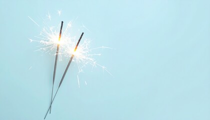 Naklejka premium Single sparkler glowing brightly against a light blue background creating a festive atmosphere