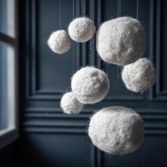 Several white fuzzy spheres hang suspended against a dark blue wall.