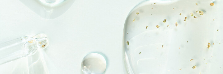 Clear liquid gel with gold flakes on light background.