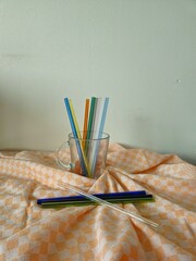 glass with multi-colored straws. Reusable glass Straws in Glass on white background. empty glass with colorful straws on a white background.
